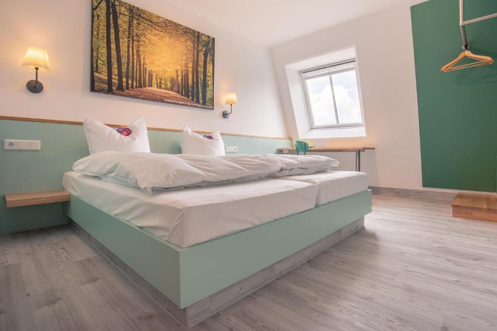 Cama grande en habitación con paredes verdes en Auszeit Das Hotel Himmelkron, en Himmelkron