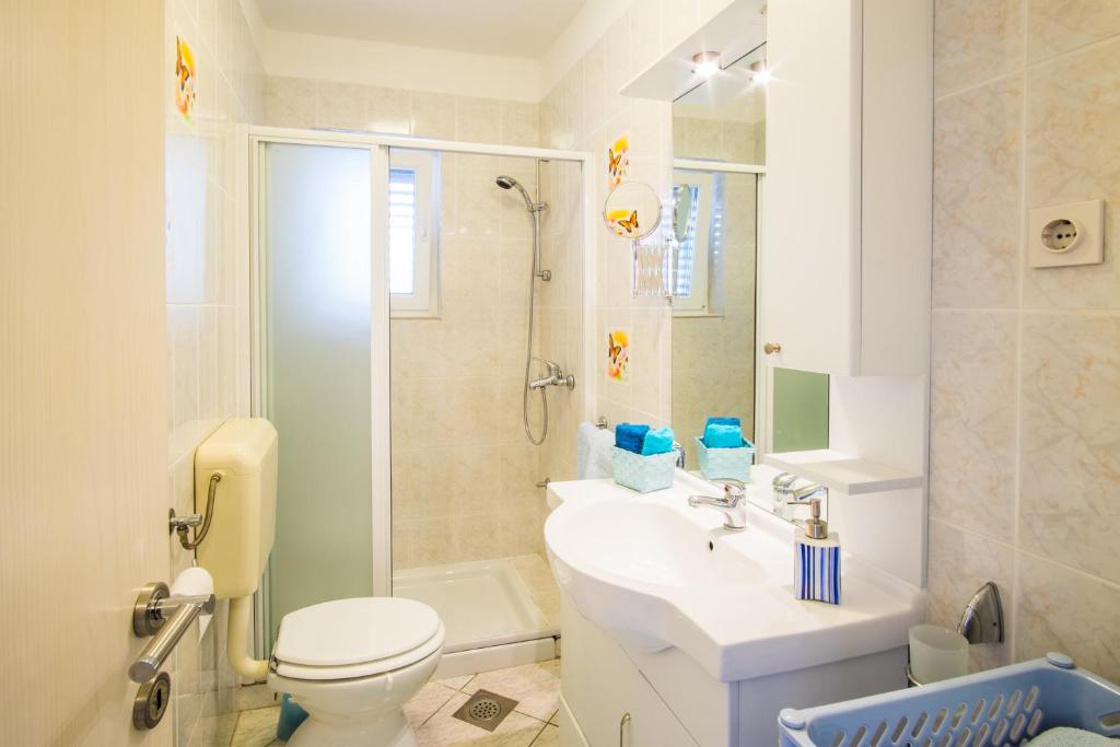 a bathroom with a toilet and a sink and a shower at Apartments Stasic in Vrbnik