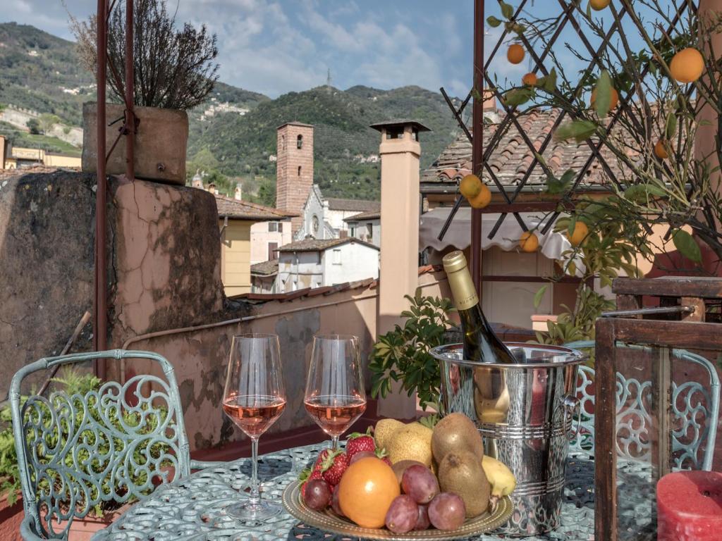 a table with wine glasses and fruit on a balcony at Hotel Palagi in Pietrasanta
