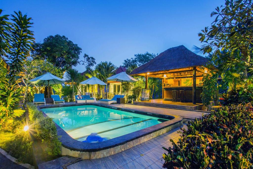 a swimming pool in front of a house at Lotus Garden Huts in Nusa Lembongan