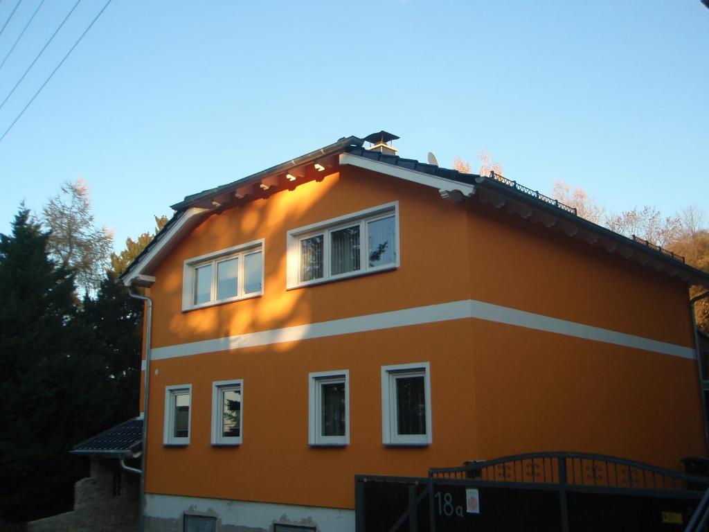 een oranje huis met witte ramen bij Ferienwohnung am Schloßberg in Arnstadt