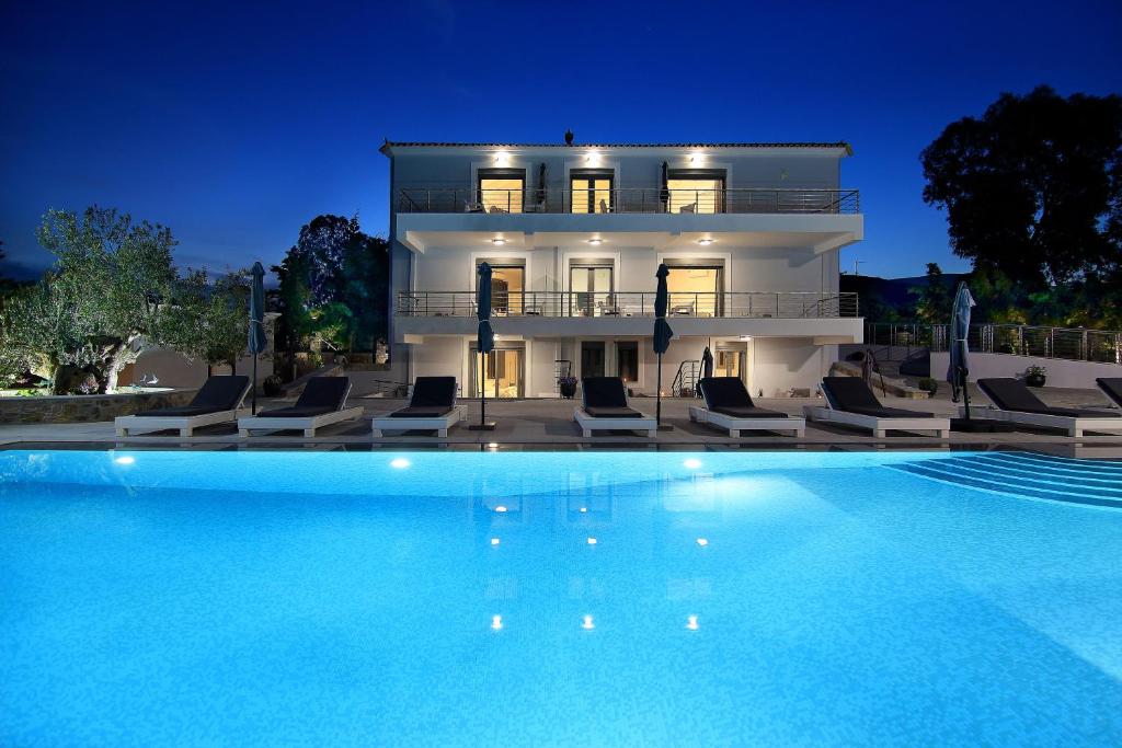 a large swimming pool in front of a house at Dardiza Boutique Hotel in Ermioni