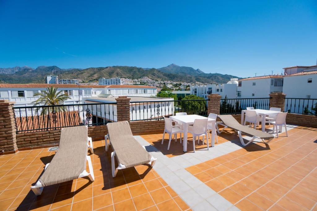 a patio with tables and chairs on a balcony at Apartamentos Manuel Martin in Nerja