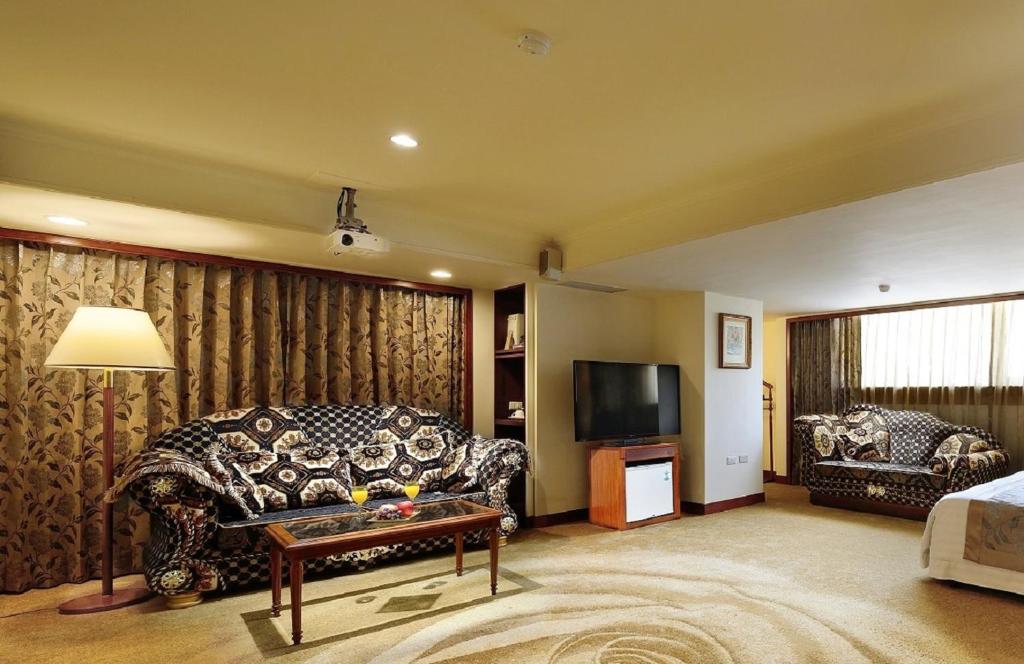 a living room with a couch and a tv at Chyuan Du Spring Resort in Taipei