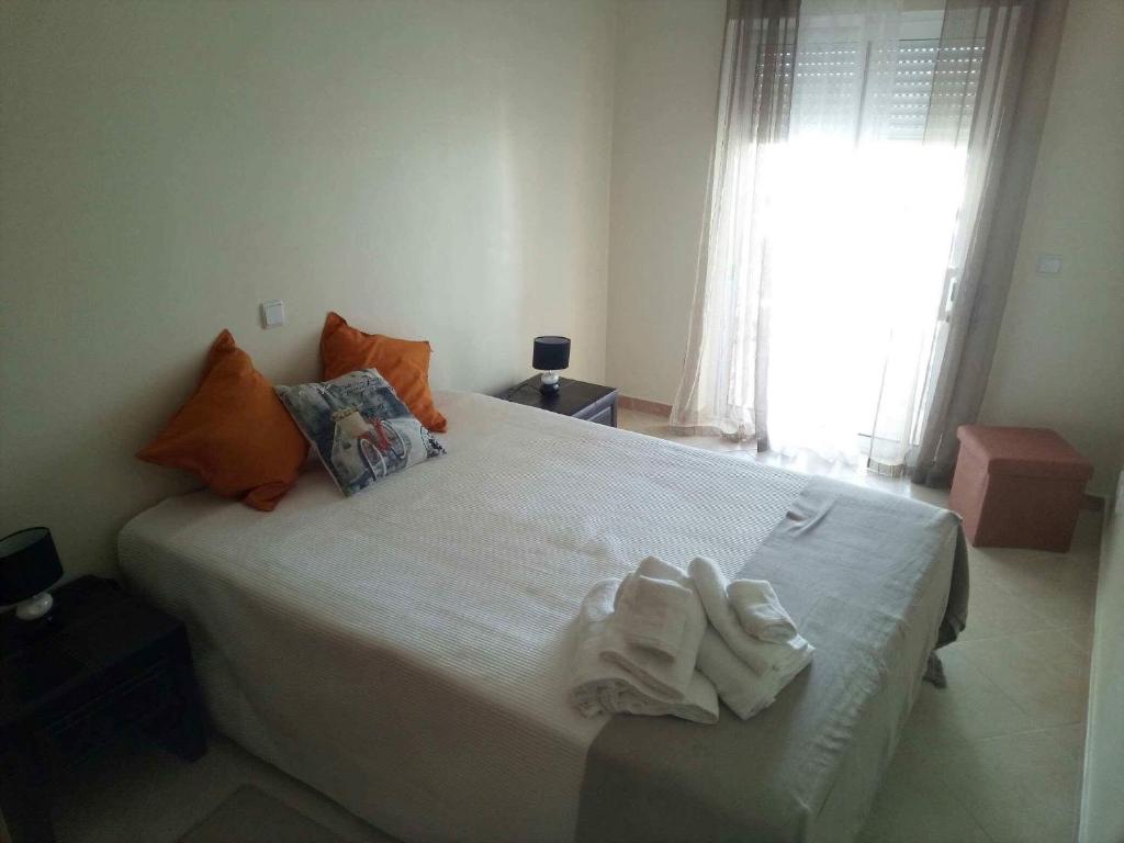 1 dormitorio con 1 cama blanca grande y ventana en Brisas da Ria, en Olhão