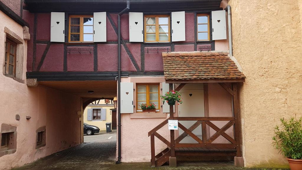 a building with a gate and a building with a porch at Gîte Groseille in Ribeauvillé