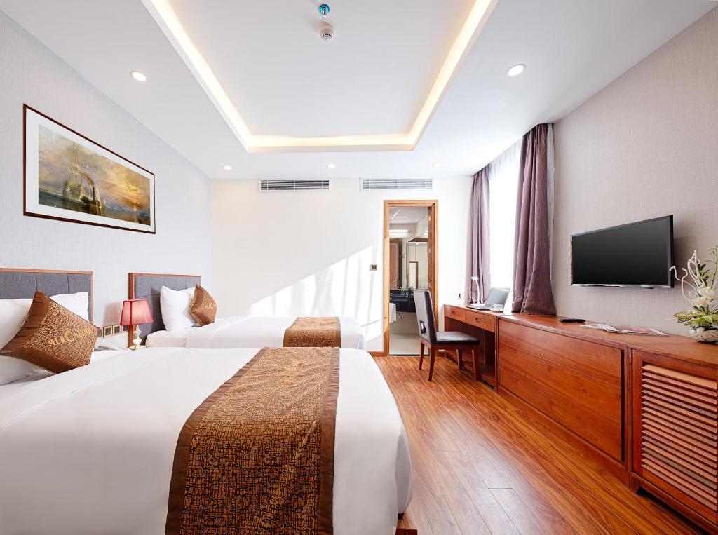 um quarto de hotel com uma cama e uma televisão de ecrã plano em Mercury Boutique Hotel & Apartment Da Nang em Da Nang