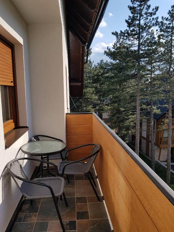 a balcony with two chairs and a table and a window at Apartmani F&A in Zlatibor