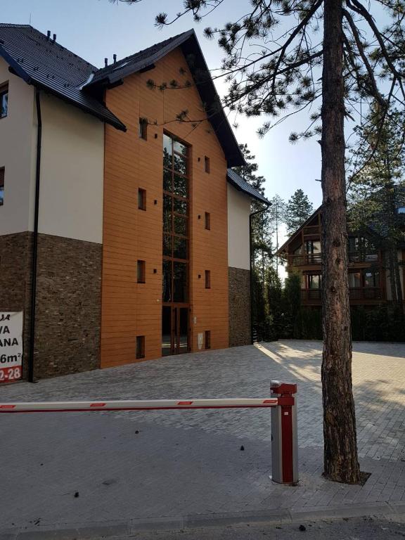 a large building with a tree in front of it at Apartmani F&A in Zlatibor