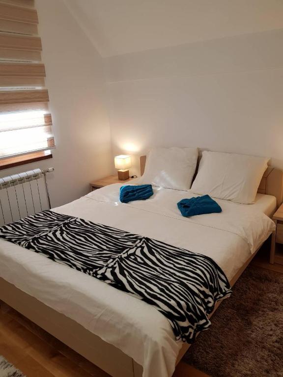 a bed with two blue pillows on top of it at Apartmani F&A in Zlatibor