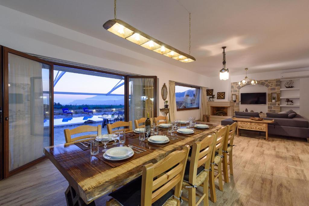 a dining room with a large wooden table and chairs at Zeus & Dione Luxury Villa in Lagolíon
