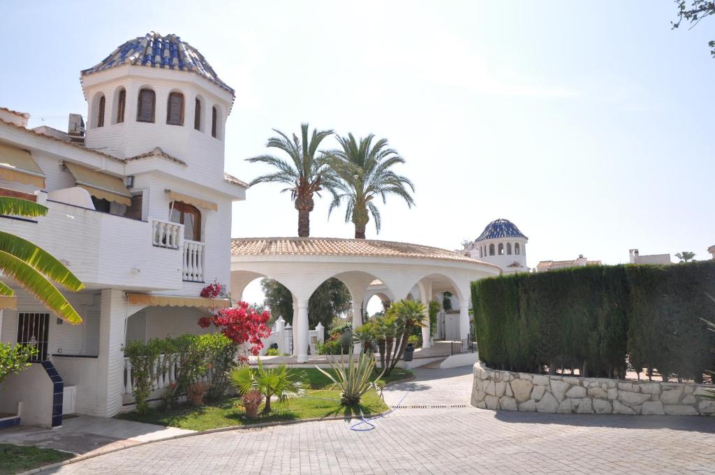 a white house with a palm tree in the background at Costahispania 308 in Gran Alacant