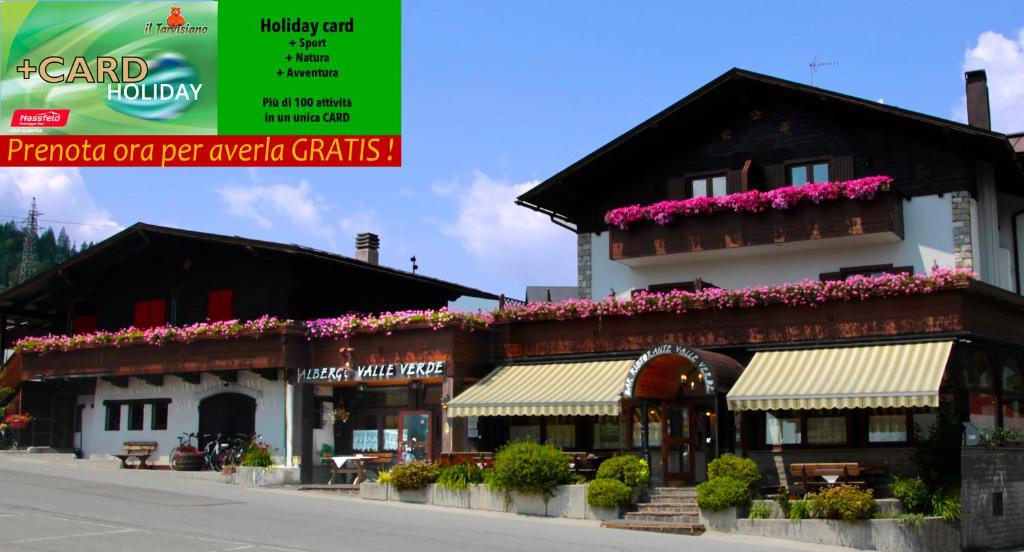 タルヴィージオにあるHotel Valle Verde - Rent Ski & Bikeの花の横の建物
