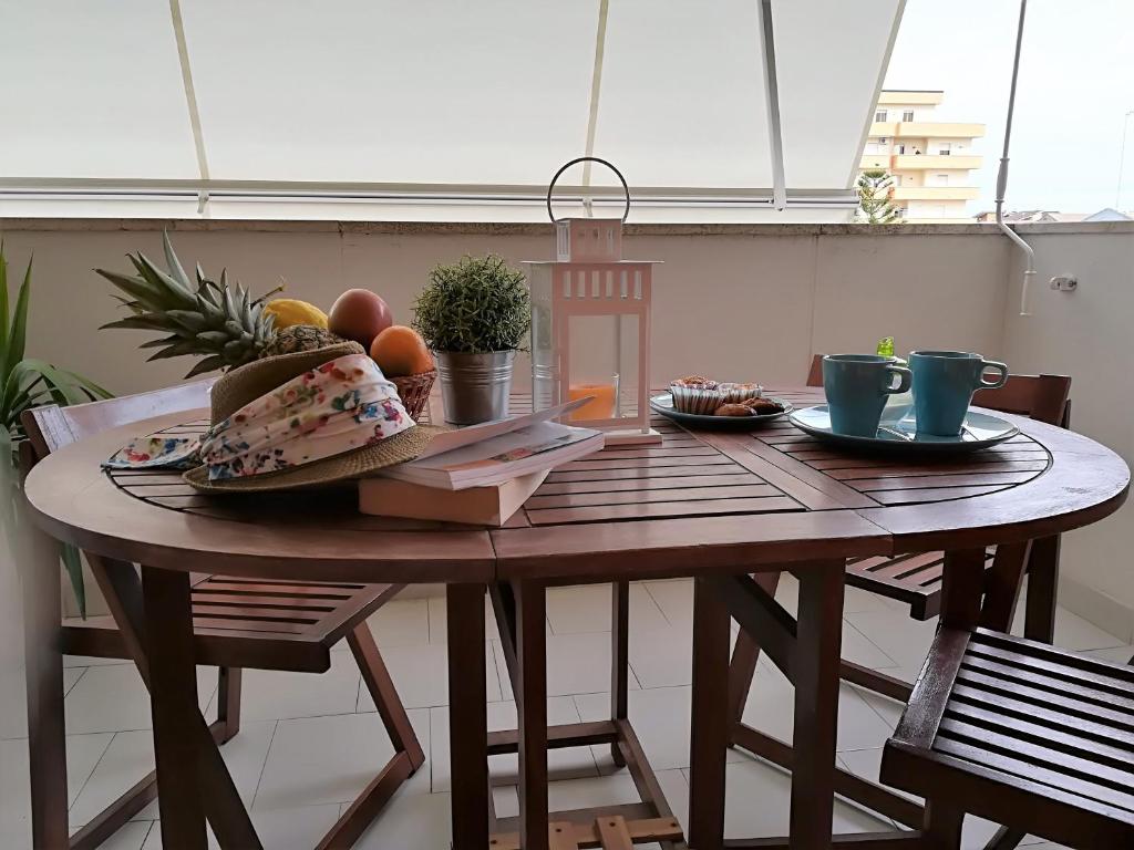 - une table en bois avec une assiette de fruits dans l'établissement Appartamentino Acquamarina, à Montesilvano