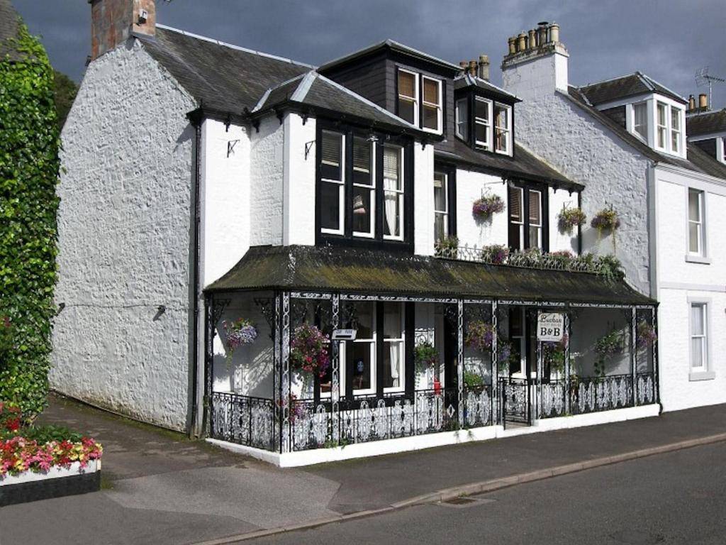 a white building with flowers on the front of it at Buchan Guest House in Moffat