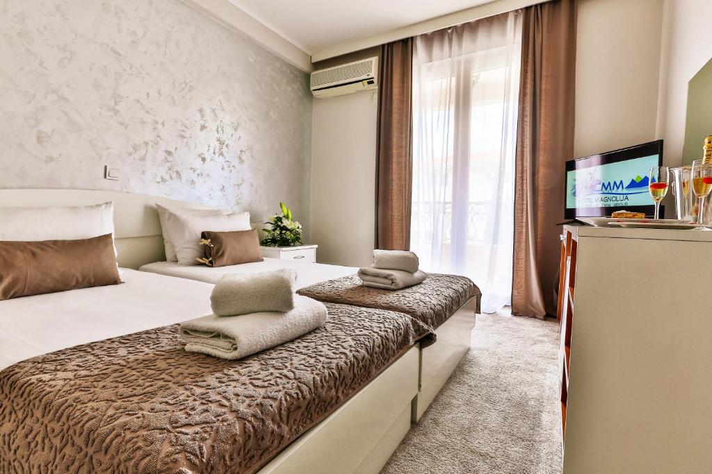 a hotel room with a bed and a television at Hotel Magnolija in Budva