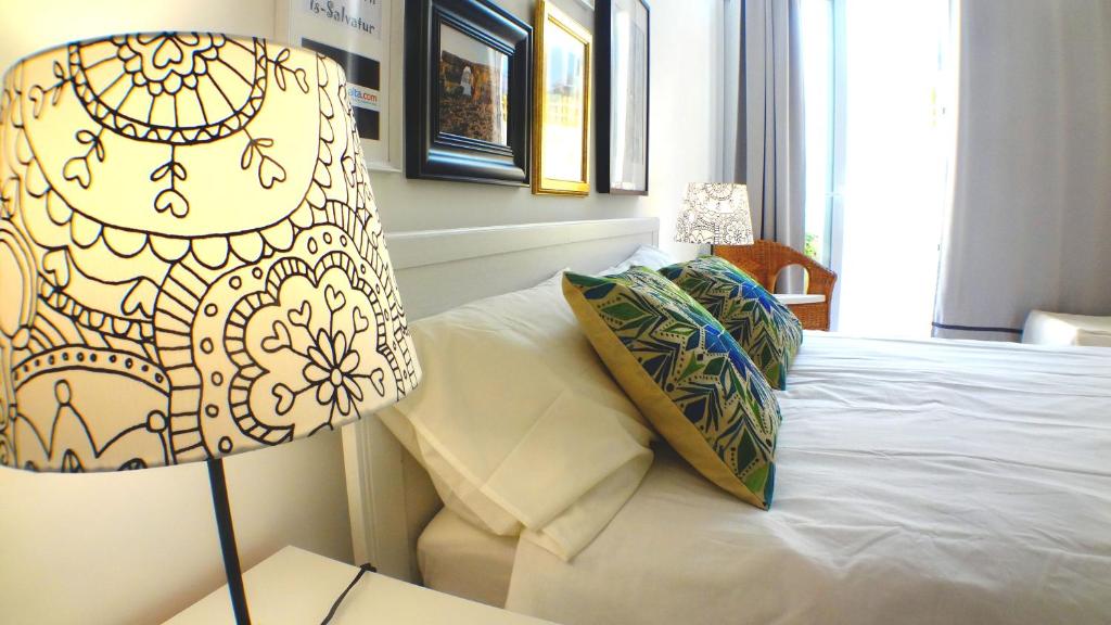 a bedroom with a bed with a lamp on it at R1101ERI by euroresort in Marsalforn
