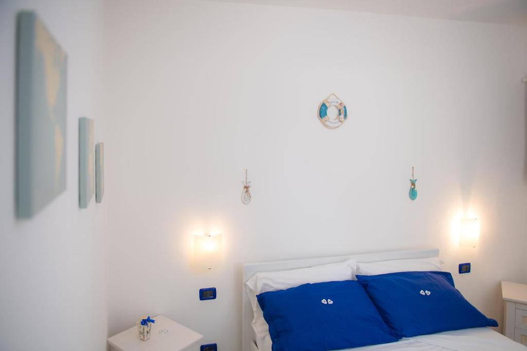 a bedroom with a white bed with blue pillows at Hotel San Giovanni in Polignano a Mare