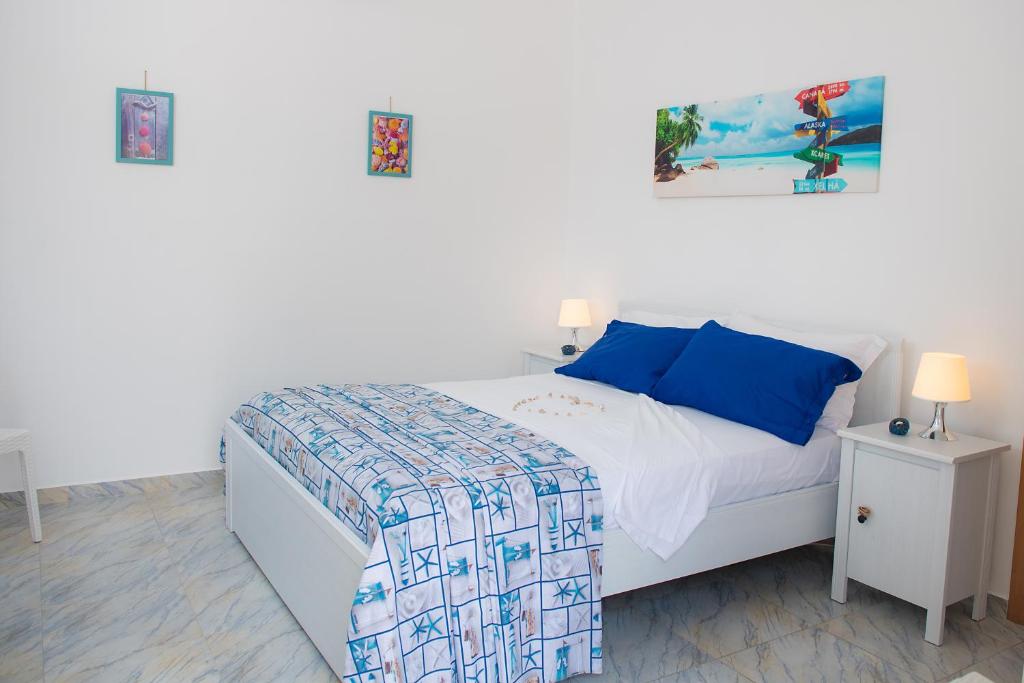 a bedroom with a white bed with blue pillows at Hotel San Giovanni in Polignano a Mare
