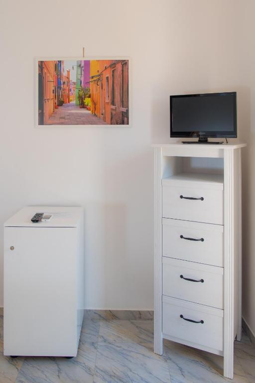 a white dresser with a television on top of it at Hotel San Giovanni in Polignano a Mare
