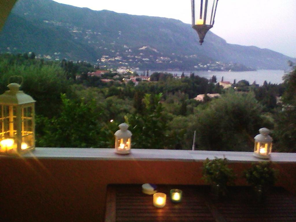 een balkon met kaarsen en uitzicht op het water bij Bella Vista in Kato Korakiana