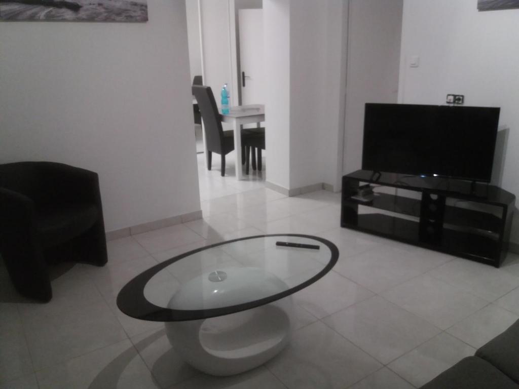 sala de estar con mesa de cristal y TV en villa rue gainekoa, en Cambo-les-Bains