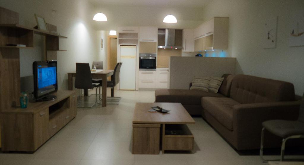 un soggiorno con divano, TV e tavolo di Serenissima House ad Amoudara Herakliou
