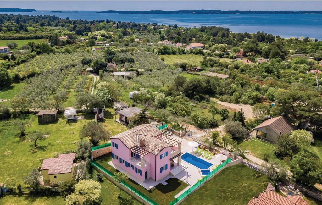 an aerial view of a pink house with a pool at Villa Peroj 1525 in Peroj