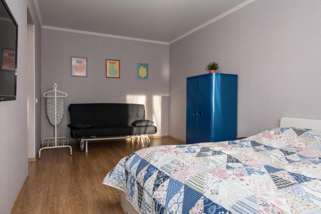 チュメニにあるСчастливая квартира на Самарцеваのベッドルーム1室(ベッド1台、青いキャビネット、椅子付)