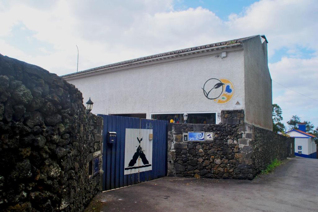a building with a blue gate and a wall at Parque de Campismo Rural Quinta das Laranjeiras in Ribeira Grande