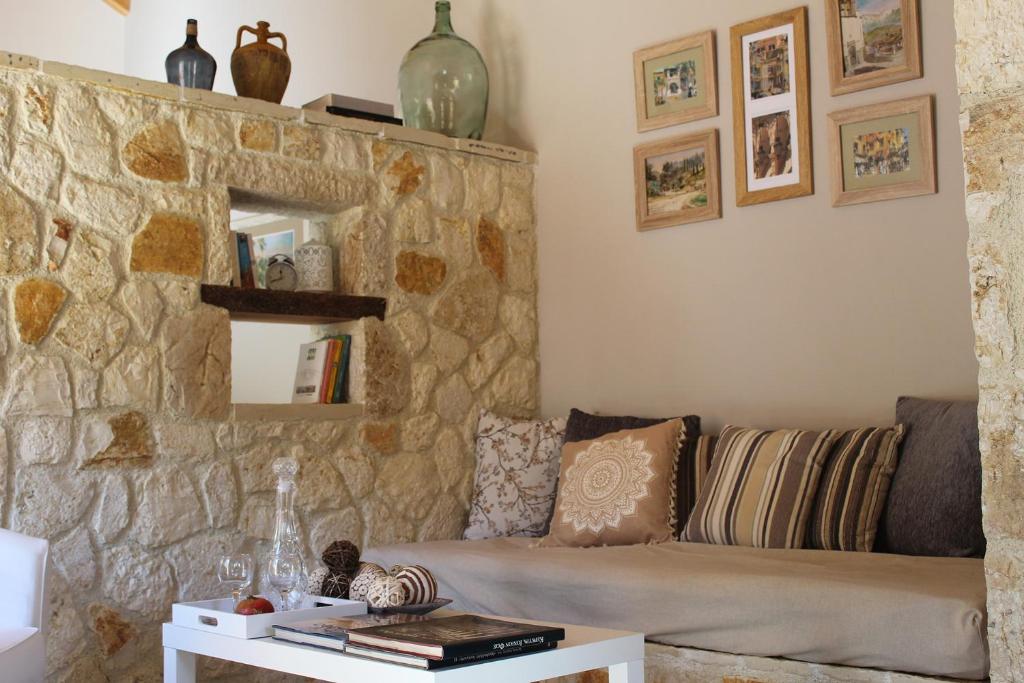 salon z kanapą i kamienną ścianą w obiekcie Eirini's House Liapades w mieście Liapades