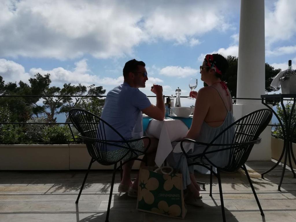 a man and woman sitting at a table on a patio at Hotel Orsa Maggiore in Anacapri