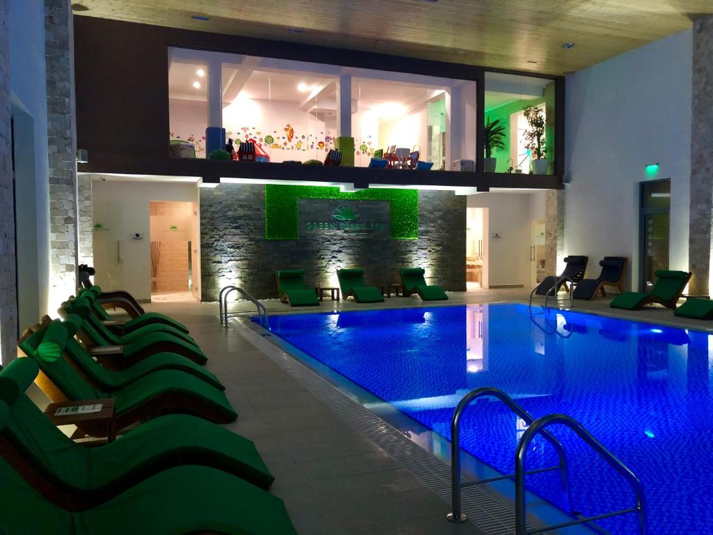 - une piscine dans un hôtel avec éclairage vert dans l'établissement Complex Turistic Magura, à Măgura
