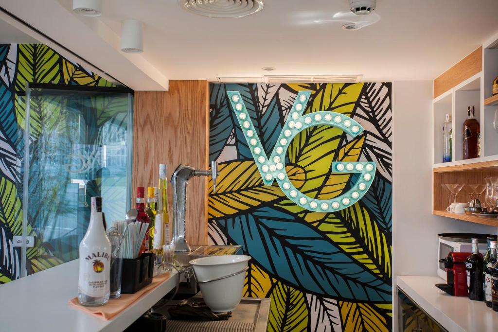 a kitchen with a colorful wall with a sign on it at Vanilla Garden Boutique Hotel - Adults Only in Playa de las Americas