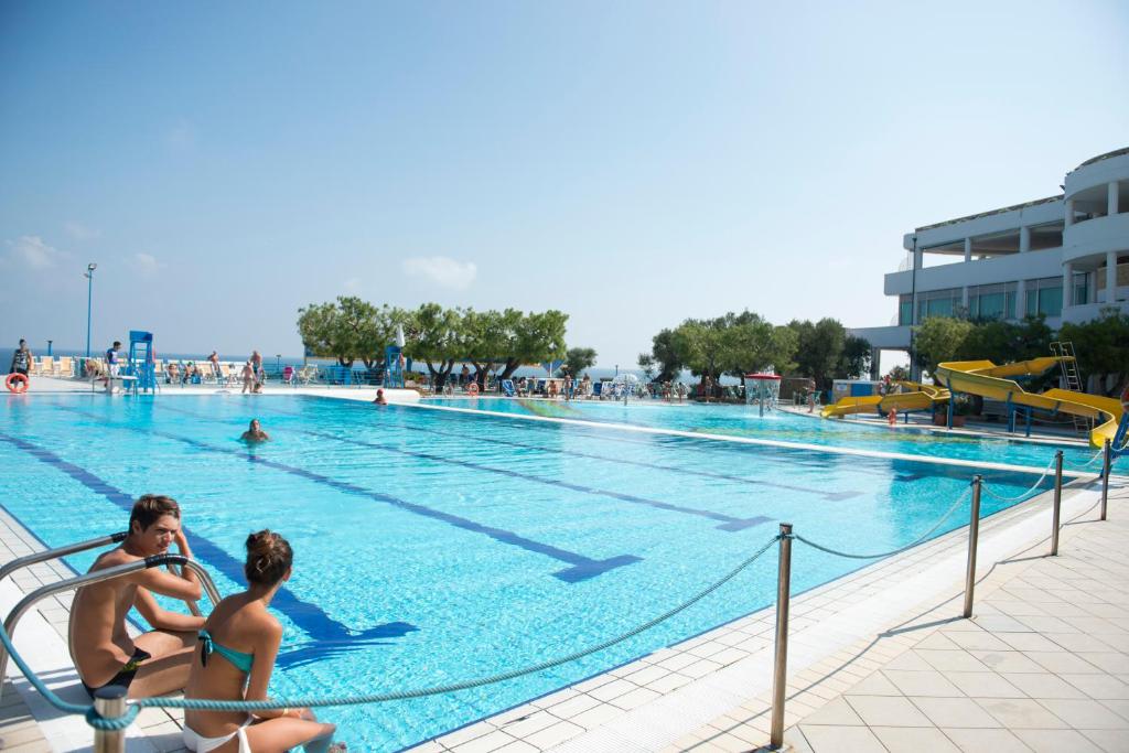 two people sitting in a swimming pool at Corvino Resort in Monopoli