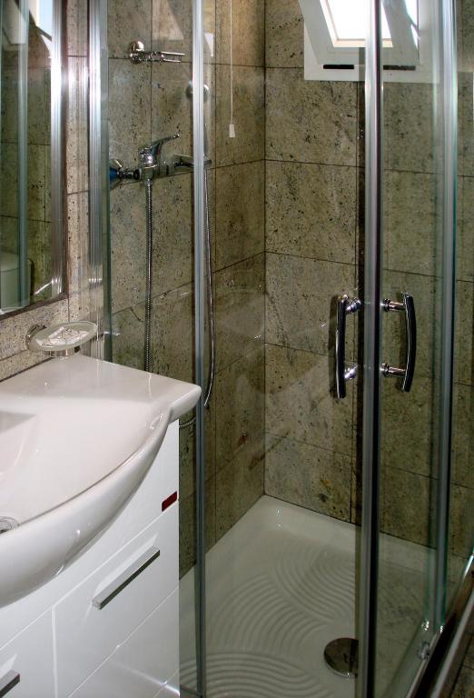 a bathroom with a shower and a sink at Patmos Paradise Hotel in Kámbos