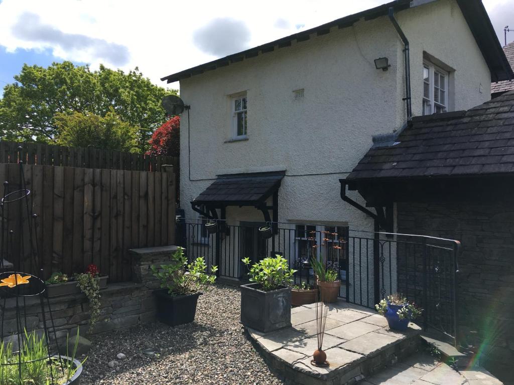 a house with a fence and some potted plants at Ivythwaite Cottages in Windermere