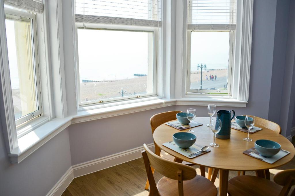 a dining room with two tables and two windows at Seaview in Worthing