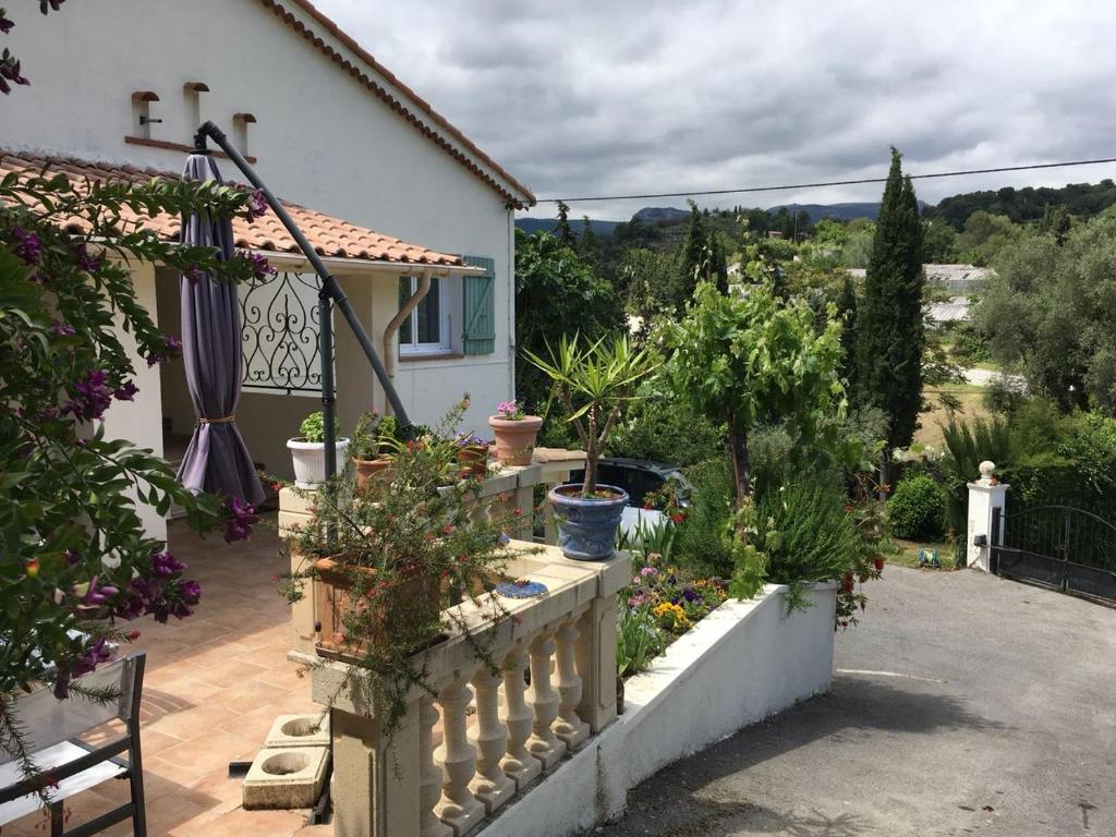 uma casa com uma varanda com vasos de plantas em La Inna em Cagnes-sur-Mer