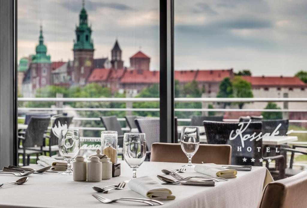 einen Tisch mit Gläsern und Servietten sowie Stadtblick in der Unterkunft Hotel Kossak in Krakau