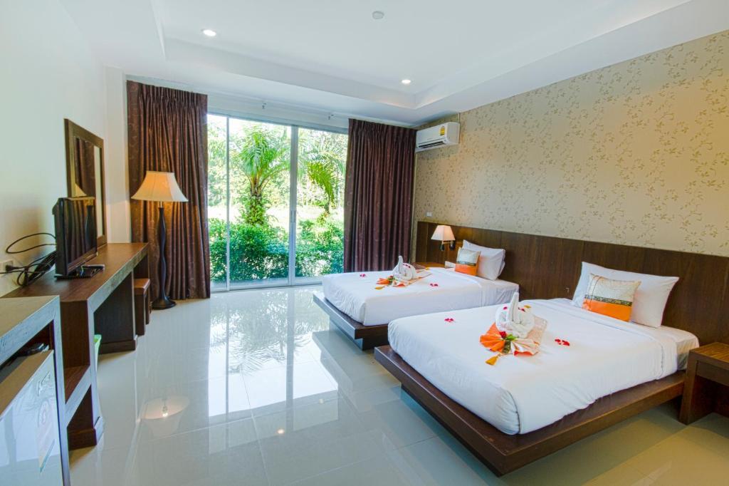 a hotel room with two beds and a television at The Pano Hotel & Residence in Ao Nang Beach