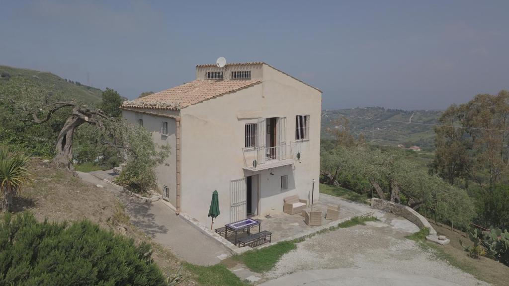 a house on a hill with a bench in front of it at Casa Margaret in Collesano