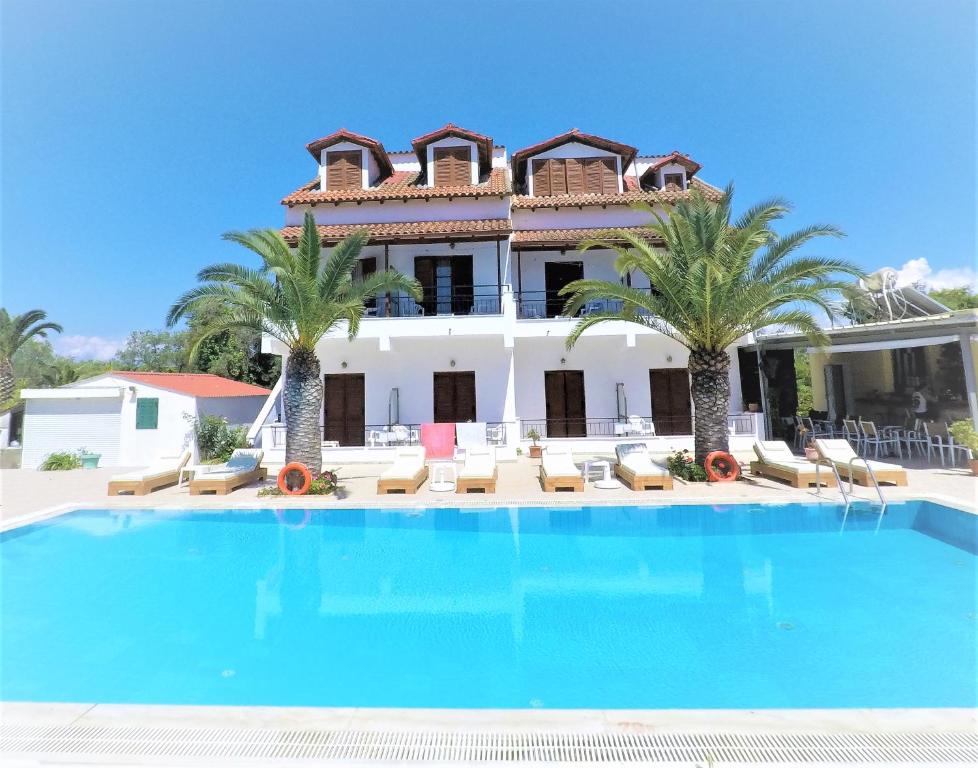 a large swimming pool in front of a villa at Captains Studios & Apartments in Kavos