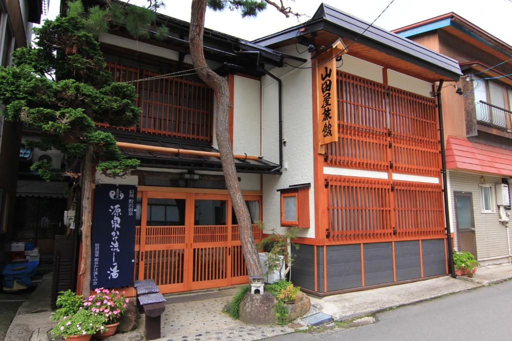 un edificio con una escritura asiática en él en Yamadaya Ryokan, en Nozawa Onsen