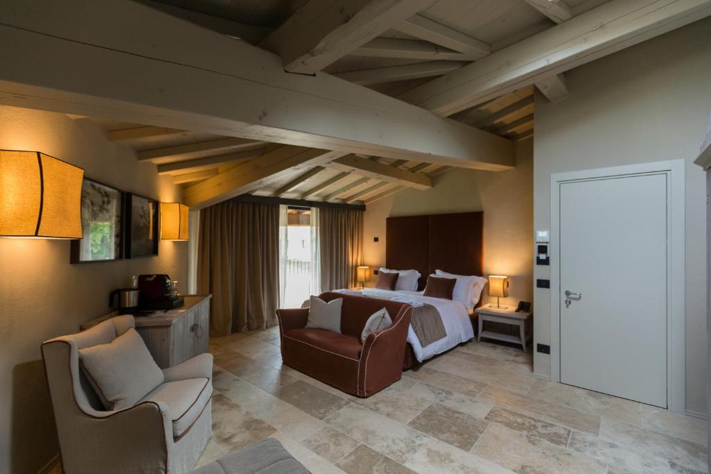 a hotel room with a bed and two chairs at Ca' del Moro Wine Retreat in Grezzana