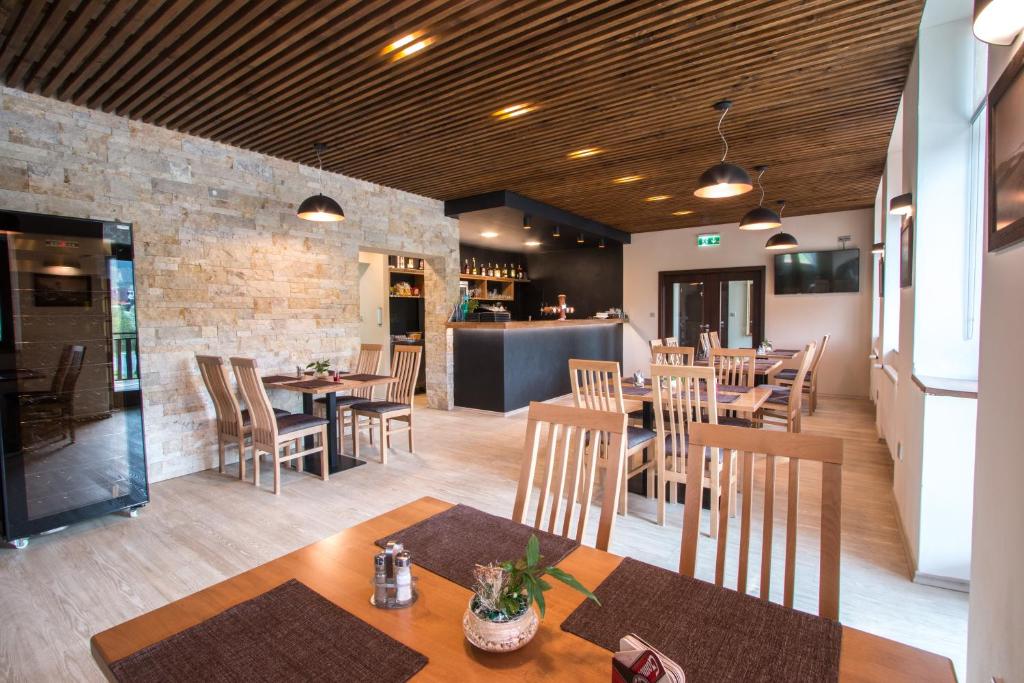 restauracja ze stołami i krzesłami oraz ceglaną ścianą w obiekcie Penzion HORA w mieście Ratiboř