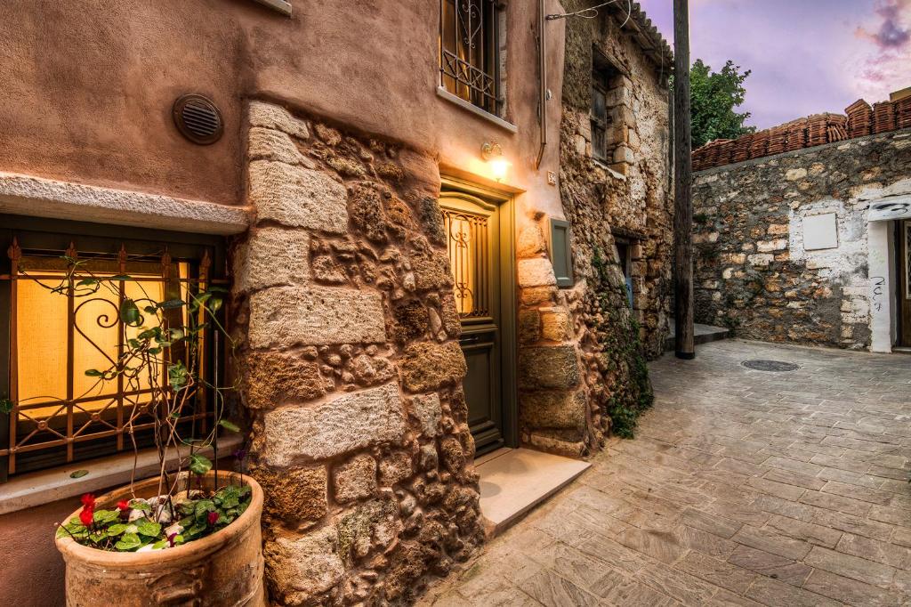 a stone building with a door and a potted plant at Elvie House in Chania