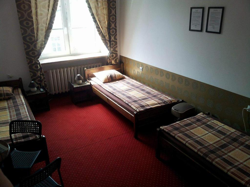 a bedroom with two beds and a window at Hostel Maxim in Warsaw