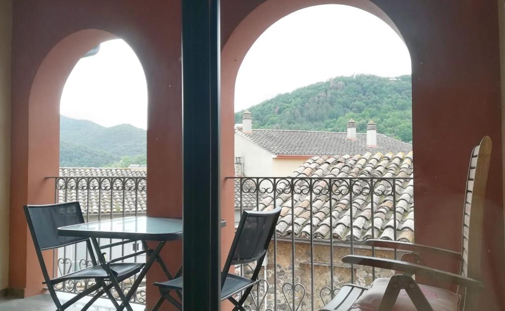 una mesa y sillas en un balcón con vistas en El Balco del Llierca, en Sant Jaume de Llierca