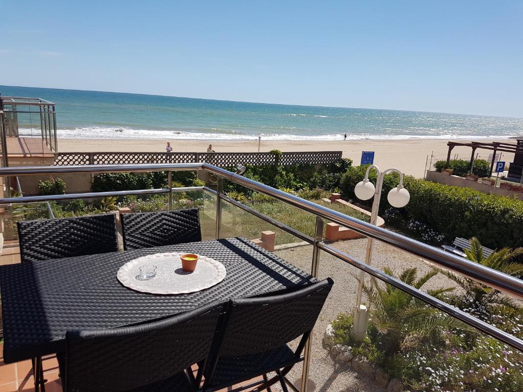 een tafel en stoelen op een balkon met uitzicht op het strand bij Gava Ocean View in Gavà